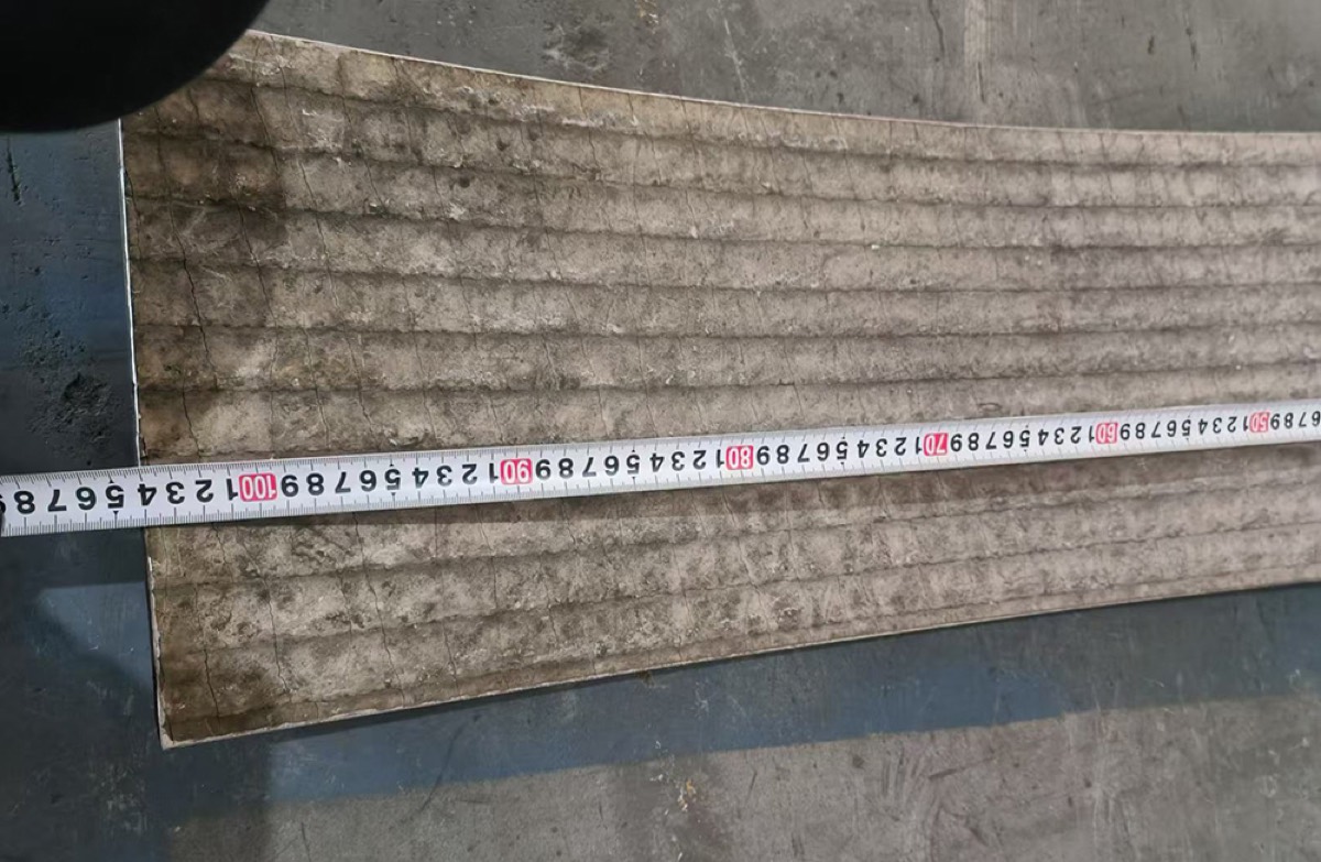 Tape measure across a curved wear liner during dimensional inspection
